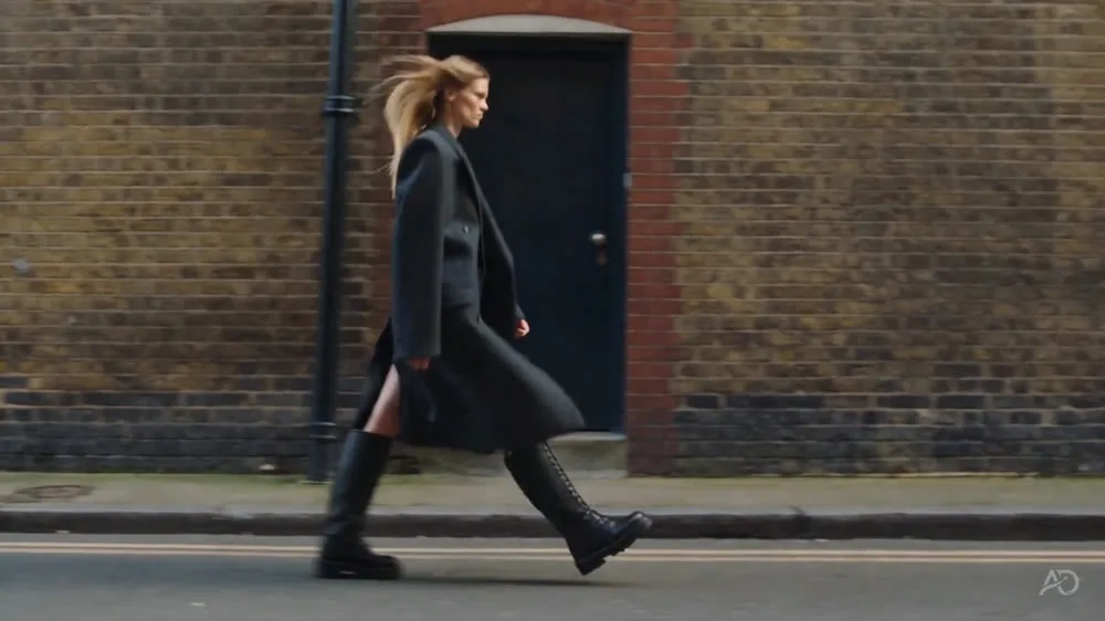 Fashion figure walking along a brick wall